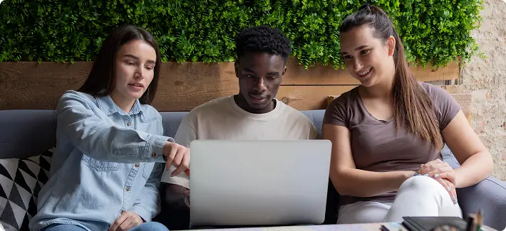 Equipe revisando prioridades em um notebook durante reunião de trabalho