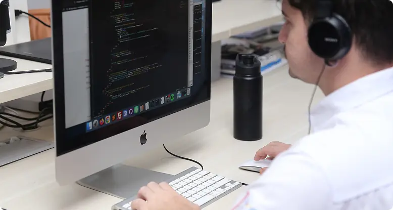 Desenvolvedor de fone de ouvido programando uma landing page em um computador
