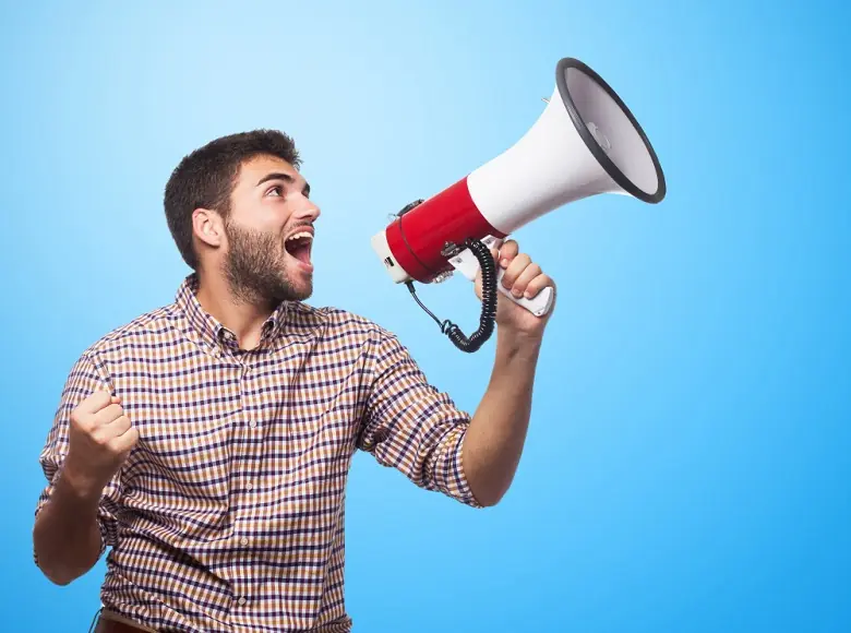 Um homem segurando uma megafone e gritando